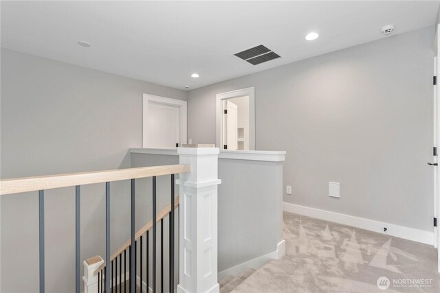 hallway featuring an upstairs landing, light carpet, baseboards, and recessed lighting