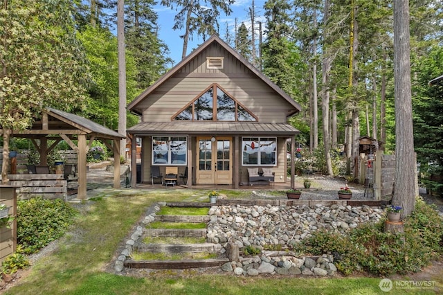 rear view of property featuring french doors, board and batten siding, and a gazebo