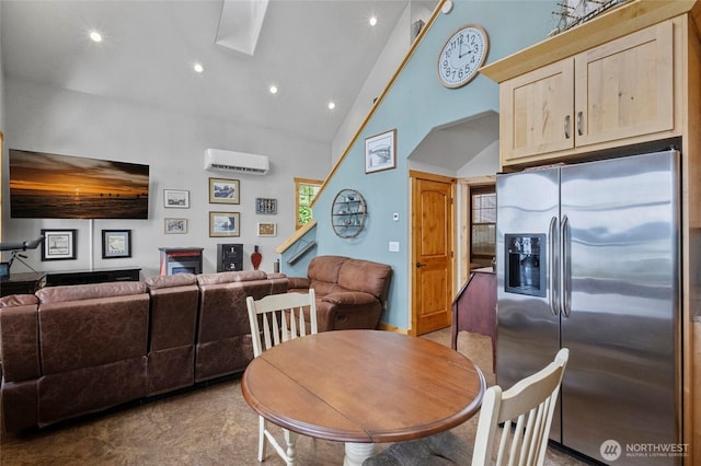 dining space with an AC wall unit, high vaulted ceiling, a skylight, and recessed lighting