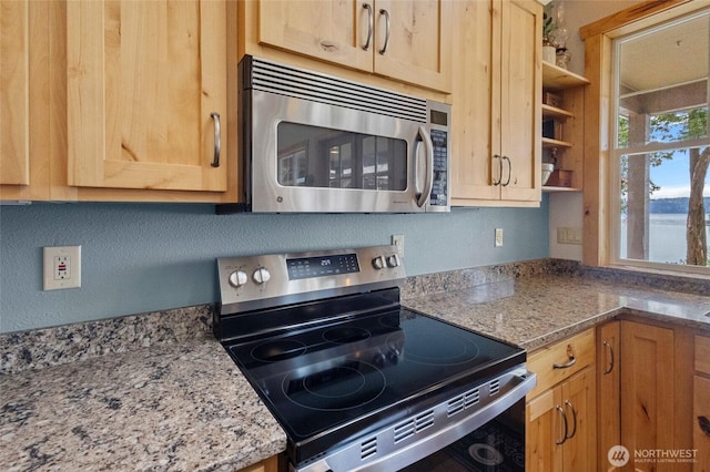kitchen featuring stainless steel appliances, open shelves, light brown cabinetry, and light stone counters
