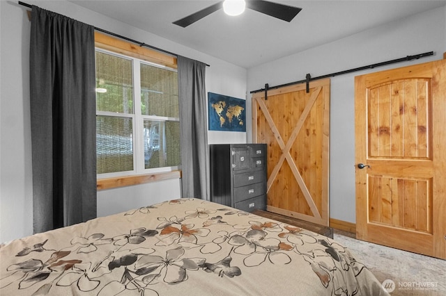 bedroom with a barn door and a ceiling fan