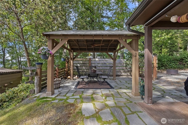 view of patio featuring a gazebo, outdoor dining space, and fence