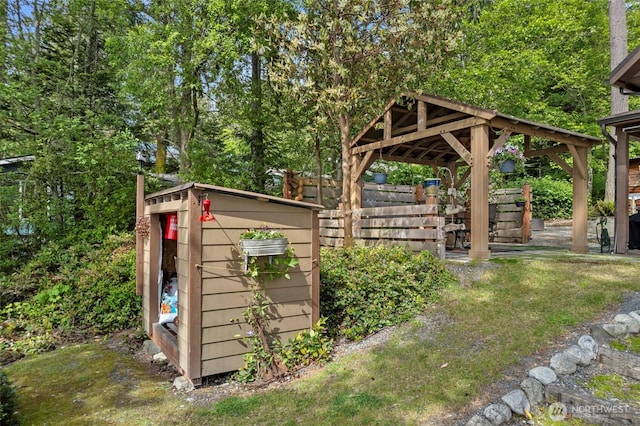 view of yard featuring an outdoor structure, a shed, fence, and a gazebo