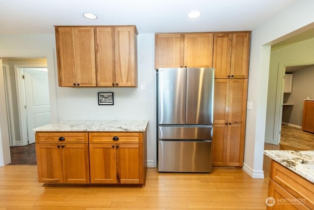 189 Hill Rd, Walla Walla, WA 99362 - kitchen with freestanding refrigerator, recessed lighting, light wood finished floors, light stone countertops, and baseboards