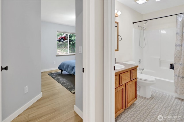 bathroom with baseboards, toilet, vanity, shower / bath combo, and wood finished floors