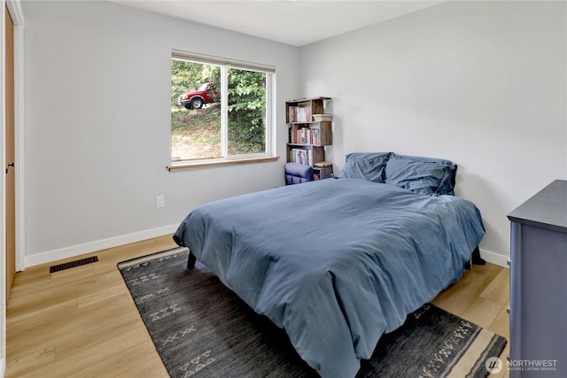 bedroom featuring baseboards and wood finished floors