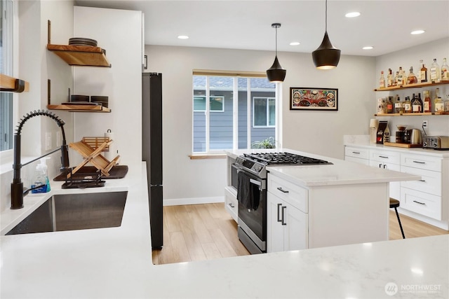 kitchen featuring open shelves, gas stove, a sink, light wood-type flooring, and recessed lighting