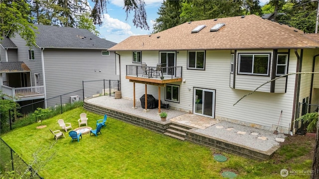 back of property featuring a fire pit, a patio, roof with shingles, and a balcony