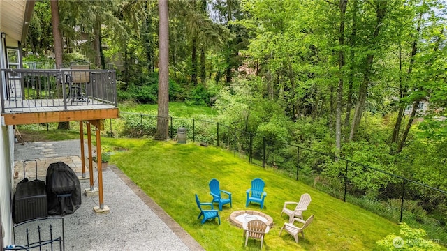 view of yard with an outdoor fire pit, a wooden deck, and a patio