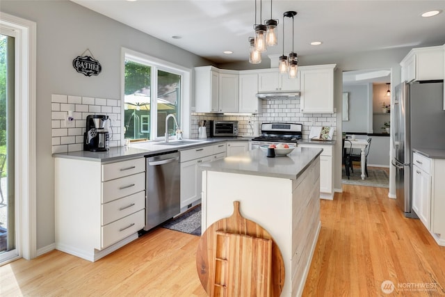 20121 3rd Ave NW, Arlington, WA 98223 - kitchen featuring stainless steel appliances, a sink, tasteful backsplash, light wood-style flooring, and white cabinetry
