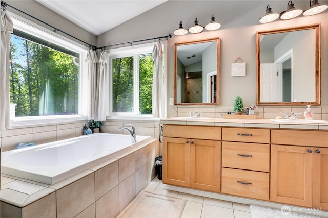 20121 3rd Ave NW, Arlington, WA 98223 - full bathroom featuring healthy amount of natural light, vaulted ceiling, tile patterned floors, a garden tub, and double vanity