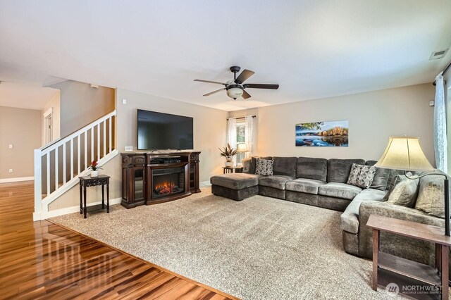19702 99th Ct E, Bonney Lake, WA 98391 - living area featuring wood finished floors, ceiling fan, stairs, a lit fireplace, and baseboards