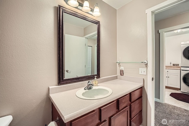 19702 99th Ct E, Bonney Lake, WA 98391 - bathroom featuring stacked washer / drying machine, vanity, and toilet