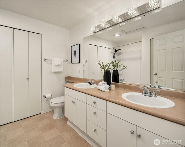 full bathroom with toilet and double vanity
