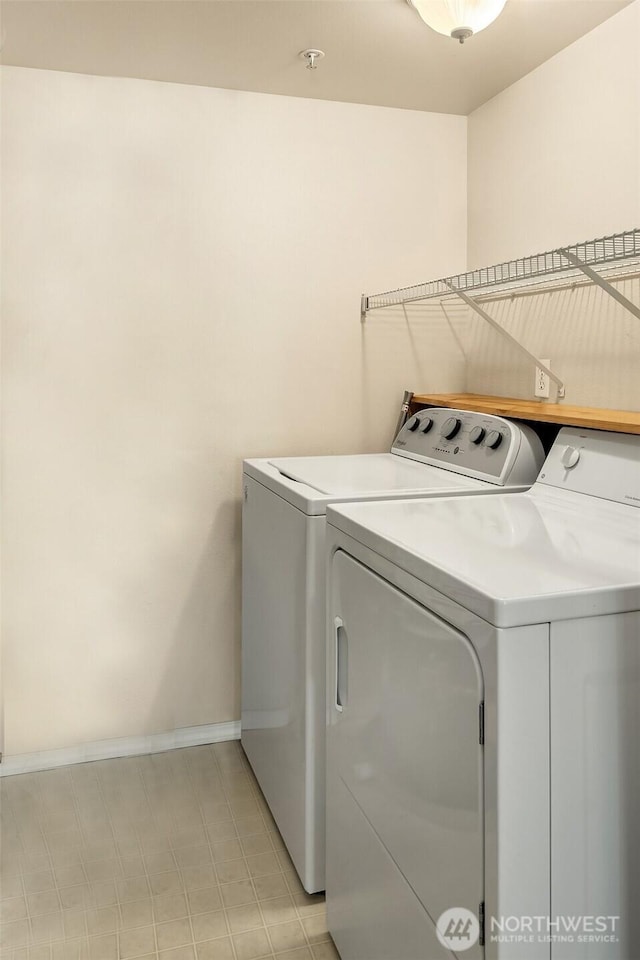 clothes washing area with washing machine and dryer and baseboards