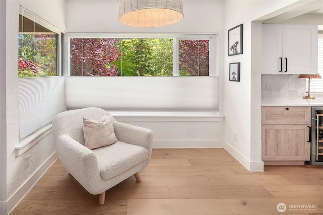 5801 Phinney Ave N Unit 103, Seattle, WA 98103 - sitting room featuring baseboards, light wood-type flooring, bar area, and beverage cooler