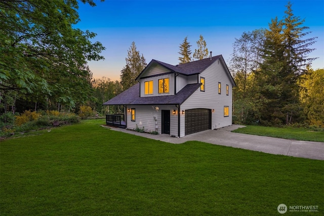view of front of house with concrete driveway, an attached garage, a front yard, and roof with shingles