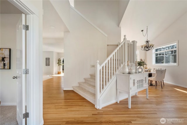 15704 124th Ave NE, Woodinville, WA 98072 - stairway with wood finished floors, a chandelier, baseboards, and a high ceiling