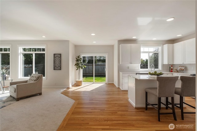 15704 124th Ave NE, Woodinville, WA 98072 - kitchen with light countertops, white cabinets, a center island, a breakfast bar area, and recessed lighting