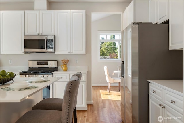 15704 124th Ave NE, Woodinville, WA 98072 - kitchen featuring stainless steel appliances, light wood finished floors, and white cabinetry