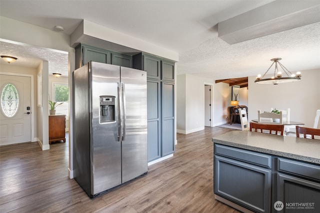 21803 NE Abernathy Rd, Yacolt, WA 98675 - kitchen with stainless steel fridge with ice dispenser, a chandelier, light wood-style floors, baseboards, and a textured ceiling