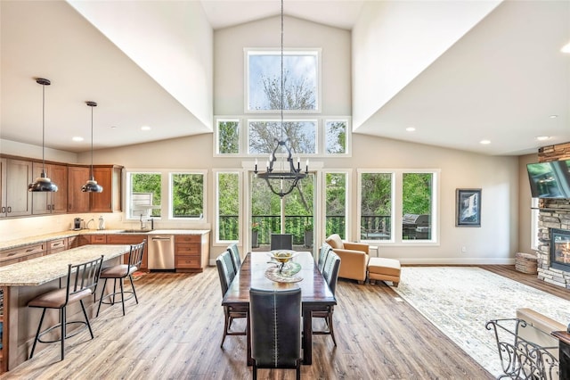 411 19th St NE Unit 9, East Wenatchee, WA 98802 - dining room with a chandelier, light wood-type flooring, high vaulted ceiling, a fireplace, and recessed lighting