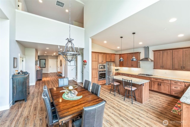 411 19th St NE Unit 9, East Wenatchee, WA 98802 - dining space featuring light wood-type flooring, high vaulted ceiling, recessed lighting, and baseboards