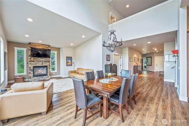 411 19th St NE Unit 9, East Wenatchee, WA 98802 - dining room with light wood-style flooring, a fireplace, baseboards, recessed lighting, and a chandelier