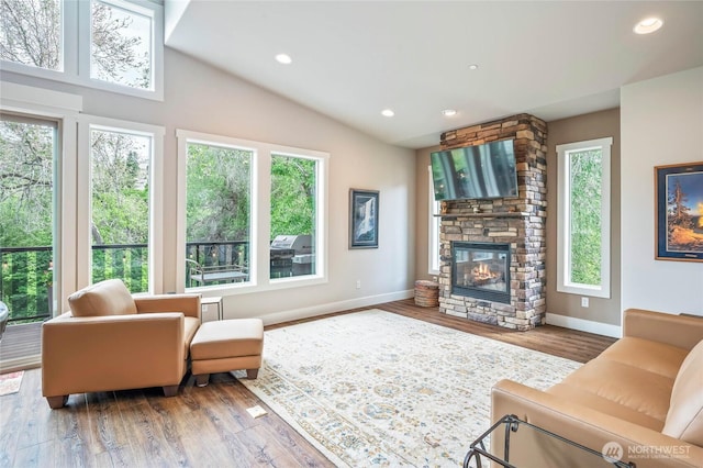 411 19th St NE Unit 9, East Wenatchee, WA 98802 - living area with plenty of natural light, a fireplace, baseboards, wood finished floors, and vaulted ceiling