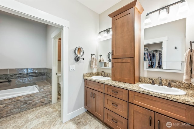 411 19th St NE Unit 9, East Wenatchee, WA 98802 - full bath featuring double vanity, toilet, a bath, baseboards, and a spacious closet