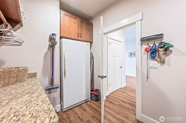 411 19th St NE Unit 9, East Wenatchee, WA 98802 - kitchen with freestanding refrigerator, wood finished floors, and light stone countertops