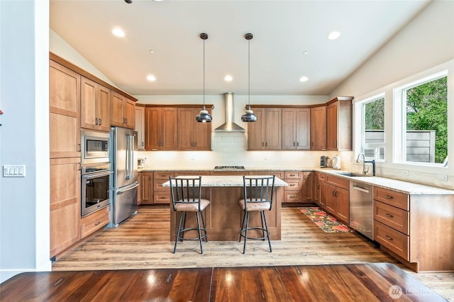 411 19th St NE Unit 9, East Wenatchee, WA 98802 - kitchen featuring appliances with stainless steel finishes, wall chimney range hood, vaulted ceiling, a sink, and a center island