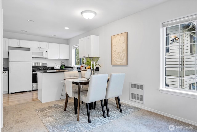 dining room featuring light colored carpet, recessed lighting, and baseboards