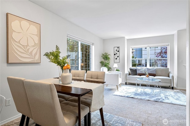 carpeted dining room with baseboards