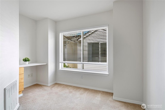 spare room with light carpet, baseboards, and plenty of natural light