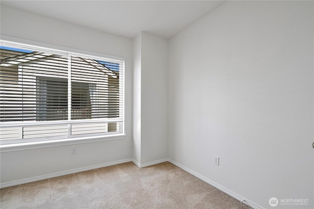 unfurnished room with light carpet and baseboards