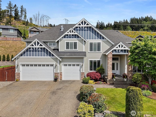 craftsman inspired home featuring driveway, stone siding, roof with shingles, board and batten siding, and an attached garage