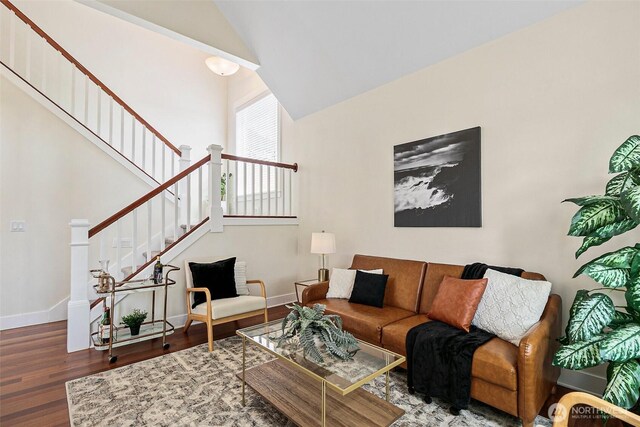 living area with wood finished floors, baseboards, stairs, and lofted ceiling
