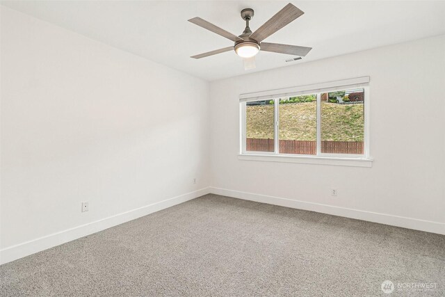 spare room with baseboards, carpet, and ceiling fan