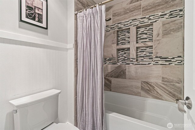 full bathroom featuring shower / bath combo with shower curtain and toilet
