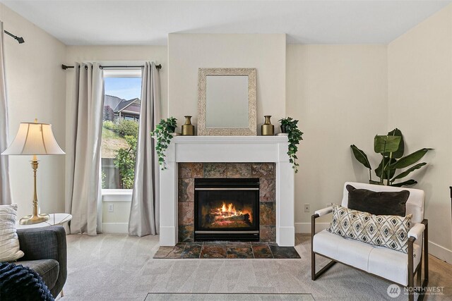 sitting room with carpet floors, a fireplace, and baseboards