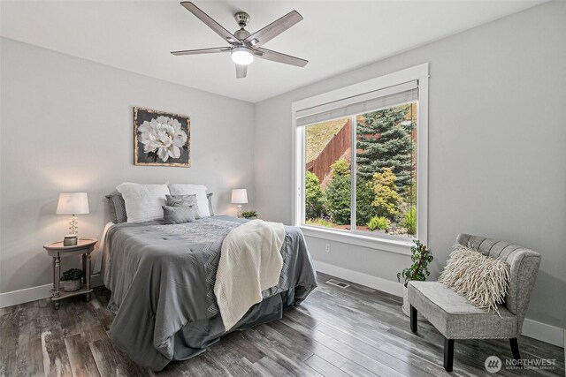 bedroom featuring baseboards, wood finished floors, and a ceiling fan