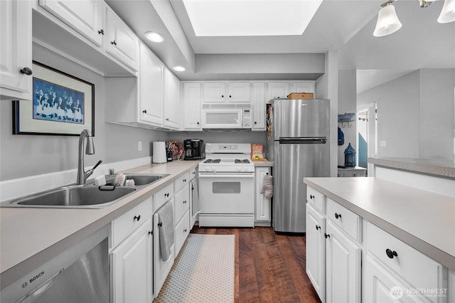 kitchen featuring appliances with stainless steel finishes, a sink, light countertops, white cabinets, and recessed lighting