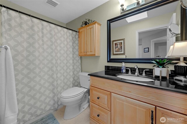 bathroom with toilet, vanity, tile patterned flooring, and curtained shower