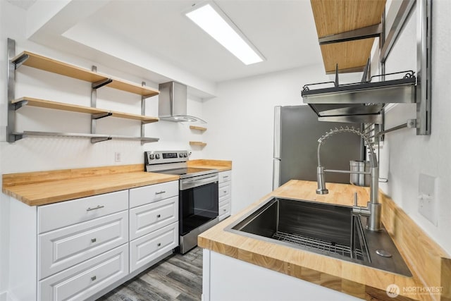 kitchen featuring butcher block counters, stainless steel electric range, wall chimney exhaust hood, a sink, and dark wood-type flooring