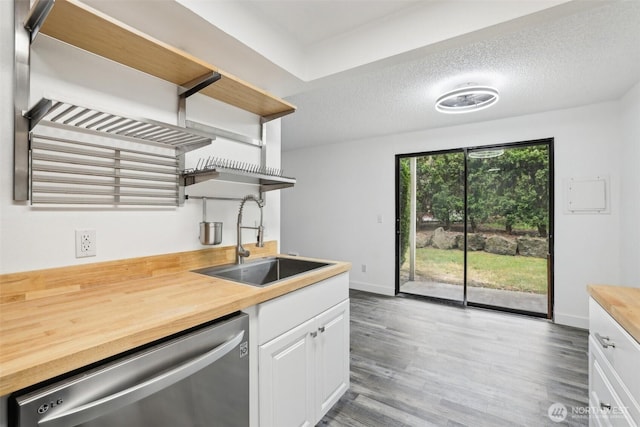 kitchen featuring open shelves, dishwasher, a sink, butcher block counters, and white cabinetry