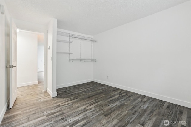 spacious closet with dark wood finished floors