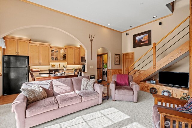 111 Connon Canyon Rd, Leavenworth, WA 98826 - living area with arched walkways, stairway, crown molding, light carpet, and a high ceiling