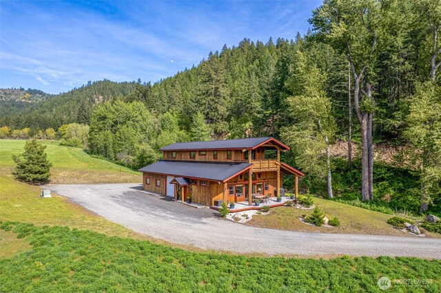 111 Connon Canyon Rd, Leavenworth, WA 98826 - view of front of home with a view of trees, covered porch, a front yard, and gravel driveway