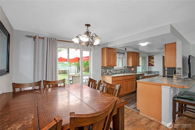 dining area with light wood-style floors and a chandelier